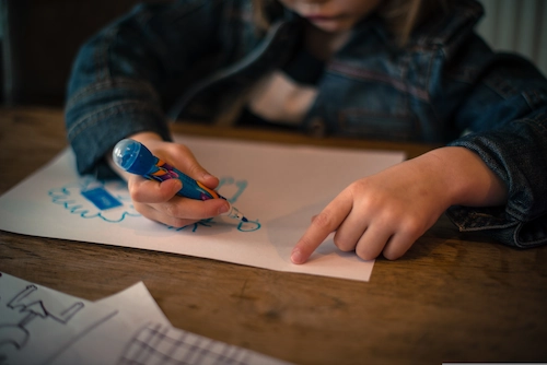 Child drawing at a table, illustrating a child-centred approach